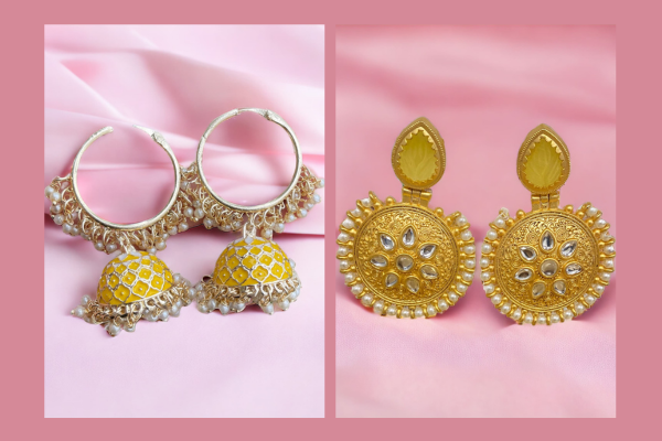 Two yellow gold earrings on a pink background. The earrings feature meenakari design with kundan and pearls. One is a jhumka bali and the other one has amrapali stone.