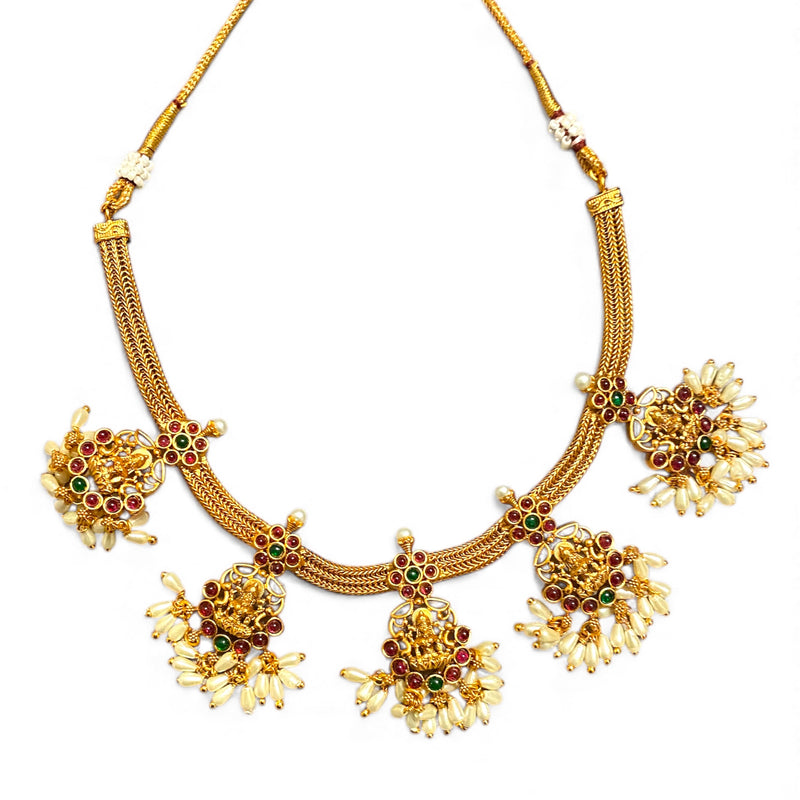 The image shows a traditional South Indian matte antique gold temple necklace displayed on a clean white background. The necklace is designed in a classical temple jewelry style, featuring a thick woven gold chain with a textured braided pattern. The warm matte finish gives the piece a rich, heritage-inspired look reminiscent of antique gold craftsmanship found in traditional South Indian jewelry.
Five ornate pendants hang from the chain, each crafted with an intricate Lakshmi motif at the center. The godde