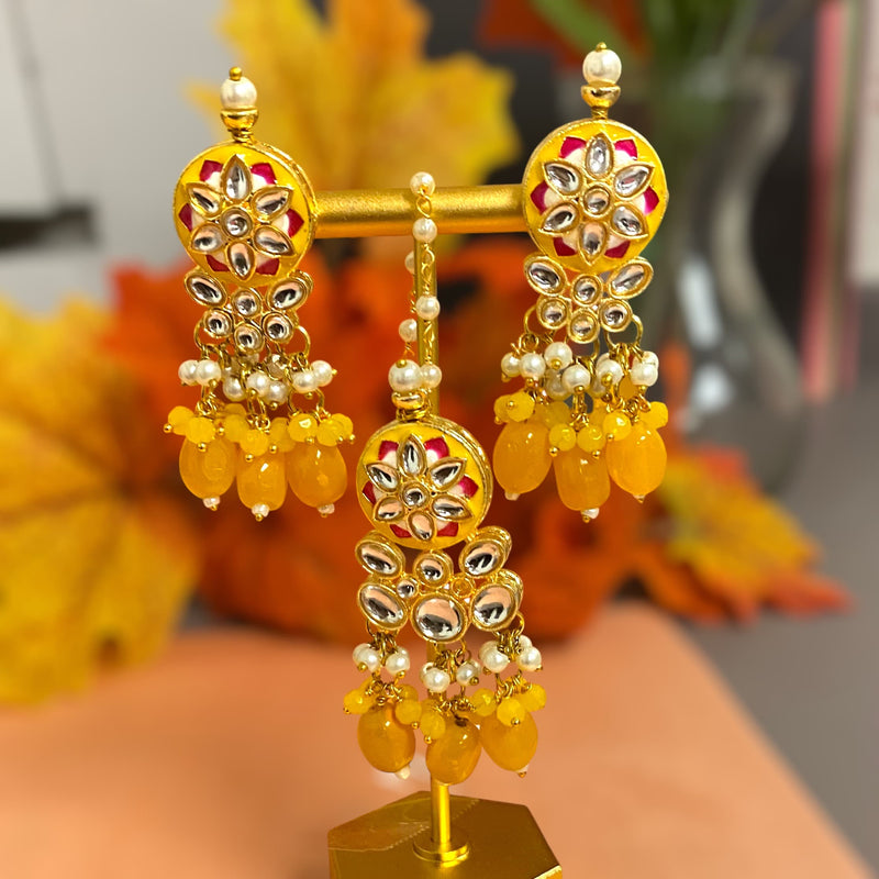 Yellow meenakari earrings with maang tikka featuring Indian jewelry. Deisgner earrrings with maang tikka with intricate design of kundan, pearls and meenakari.