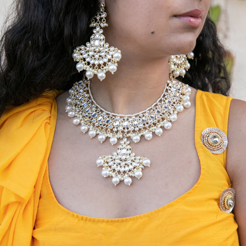Model wearing Indian Jewelry Kundan KNecklace set with kunan and pearls.