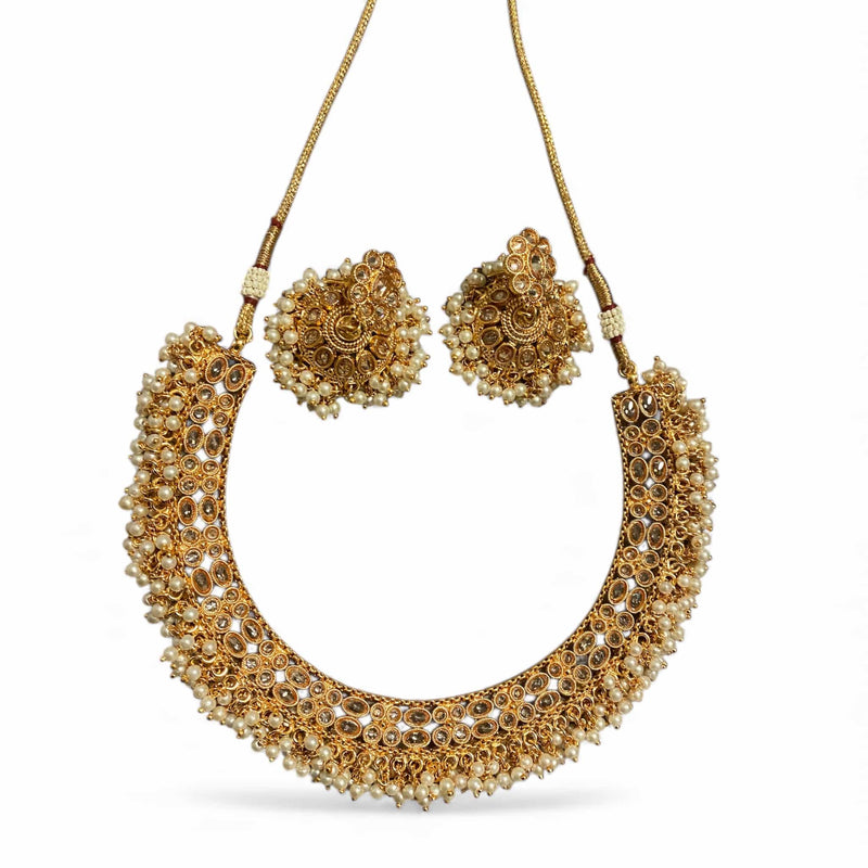 Handcrafted South Indian Guttapusalu necklace set with Polki stones and premium pearl clusters in antique gold finish. Features traditional temple jewelry detailing and cascading pearl bunches. Ideal for bridal wear, weddings, festivals, and cultural celebrations. Elegant Polki and pearl design inspired by Andhra and Tamil heritage craftsmanship.