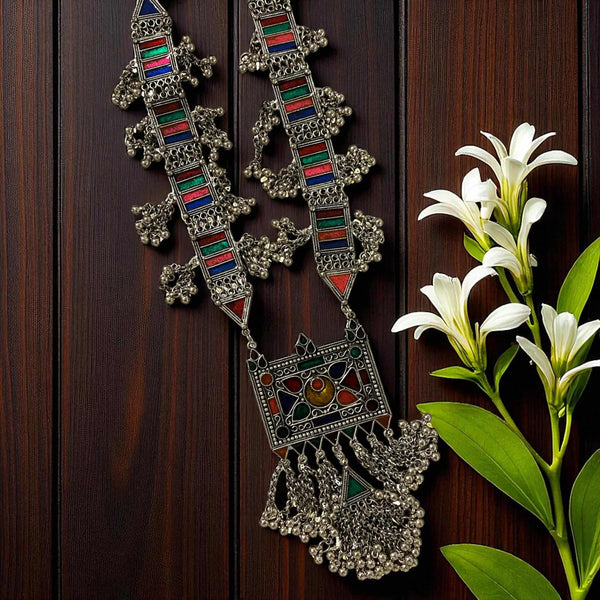Aradhya German Silver Multicolor Ghungroo Necklace featuring intricate oxidized silver work with red, green, and blue enamel detailing. This handcrafted tribal statement necklace includes dangling ghungroos for a traditional boho look. Perfect ethnic jewelry piece for festivals, weddings, or cultural events. A stunning handmade long Afghan-style necklace that adds vintage and artistic charm to any outfit.