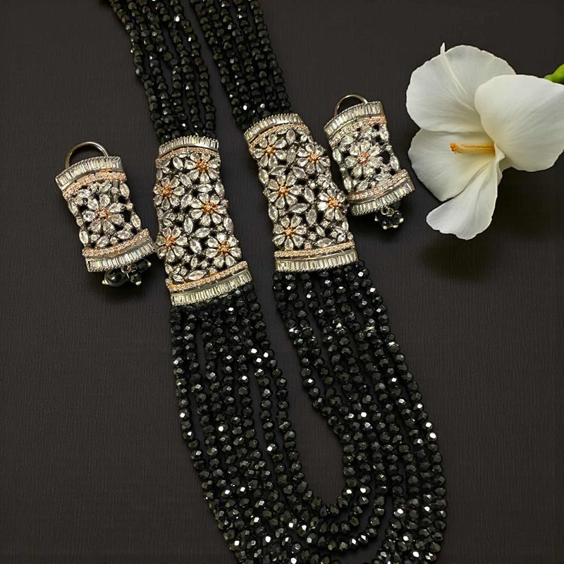 Black Pearl Mahima CZ Long Necklace Set with CZ Flowers | Elegant Indian jewelry featuring lustrous black pearls and sparkling cubic zirconia floral motifs in gold plating | Includes matching CZ floral earrings | Perfect for weddings, festive occasions, and evening celebrations | Traditional yet modern Indian jewelry by Romikas | Handcrafted statement set exuding sophistication, luxury, and timeless cultural charm