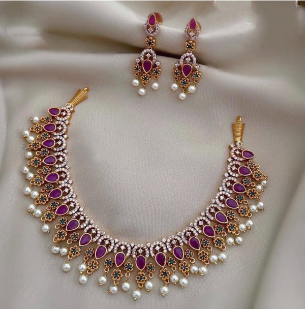 A stunning gold and AD temple necklace set featuring intricate temple-inspired motifs, sparkling American Diamond stones, and rich ruby accents. Ethnic Jewelry for Weddings & Festivals. Traditional Temple Design. Bridal Jewelry.