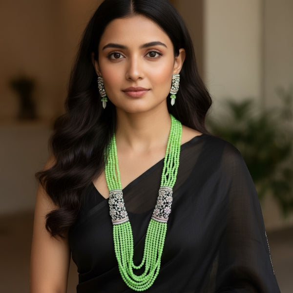 Model wearing the Parrot Green Pearl Mahima CZ Long Necklace Set with CZ Flowers | Stunning Indian jewelry featuring bright parrot green pearls and shimmering cubic zirconia floral accents in gold plating | Includes matching CZ floral earrings | Perfect for weddings, parties, and festive celebrations | Traditional yet modern Indian jewelry by Romikas | Elegant statement necklace adding freshness, radiance, and sophistication to any ethnic outfit