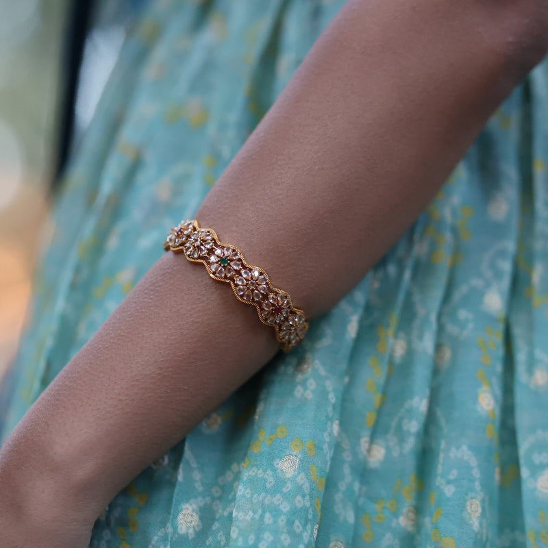 Model wearing Indian, Pakistani Bangles with polki, emerald and ruby stoens.