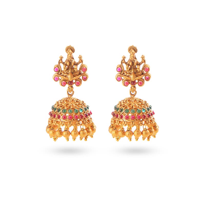 Earrings with Goddess Lakshmi, adorned with Ruby and Green stones and pearls on a matte gold finish. This bespoke South Asian jewelry piece is available in our Indian Jewelry store in the USA.