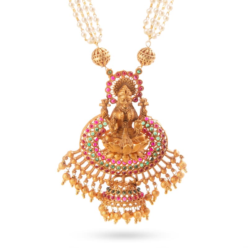 South Indian long necklace with Goddess Lakshmi, adorned with Ruby and Green stones and pearls on matte gold finish. This bespoke luxury gold set is available in our Indian Jewelry store in California.