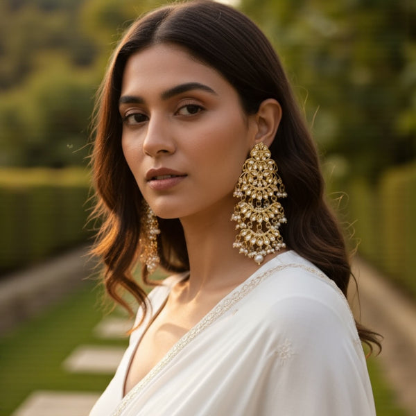 Woman wearing high quality gold plated Kundan chandbali earrings with delicate pearl drops, showcasing the intricate handcrafted design and elegant traditional Indian style. Perfect bridal and festive jewelry look, highlighting how the earrings pair with sarees, lehengas, and ethnic outfits.