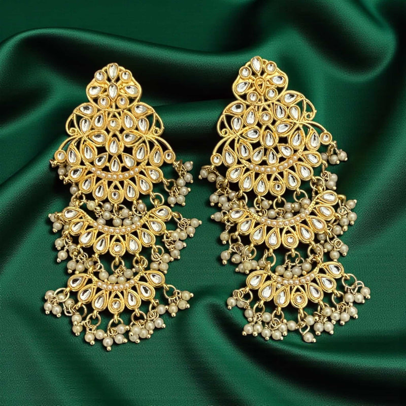 Luxury gold plated Kundan earrings with classic chandbali styling and soft pearl accents, crafted to elevate any traditional or festive look. The intricate stone setting, premium polish, and hand-placed pearls create a regal aesthetic ideal for brides, bridesmaids, and partywear. These earrings capture the essence of Indian heritage jewelry and pair beautifully with wedding attire, festive outfits, and elegant evening looks. A perfect statement accessory for gifting or adding premium South Asian craftsmansh