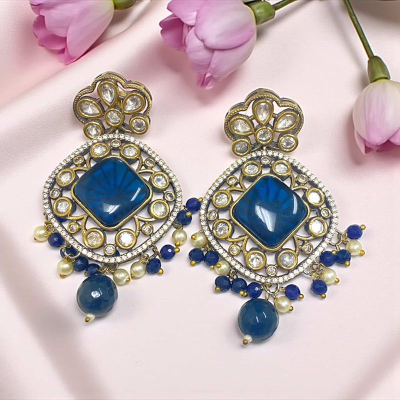 Royal Blue Kundan Earrings with intricate Polki detailing and silver foil back meenakari design. These statement earrings feature a square blue stone at the center surrounded by sparkling Kundan and delicate pearls. The dangling blue Monalisa beads add a regal charm, making them perfect for weddings, festivals, and traditional occasions. Handcrafted with gold plating and fine craftsmanship, these earrings pair beautifully with sarees, lehengas, and ethnic outfits for a royal Indian look.