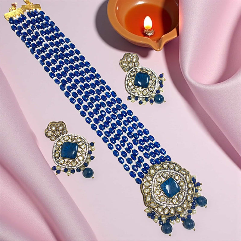 Exquisite Royal Blue Kundan Necklace Set with Earrings showcasing traditional craftsmanship and silver foil back meenakari artistry. The necklace features layered blue beads with a statement Polki pendant, while the matching earrings radiate elegance with blue Monalisa stones and pearl drops. Perfect for brides and festive celebrations, this handcrafted gold-plated set enhances any ethnic attire with its regal glow and luxurious, timeless Indian jewelry appeal.