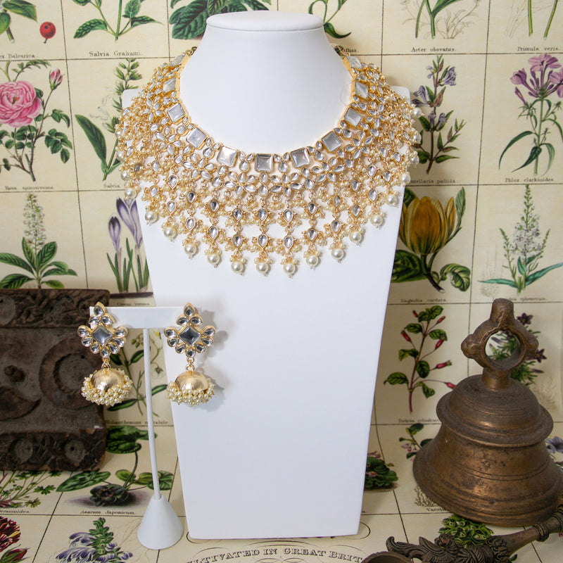 Indian Bridal Jewelry featuring Kundan Necklace Set with Pearls on gold with jhumkas.