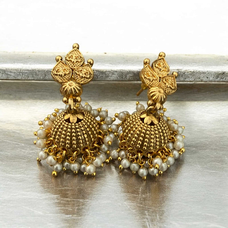 Gold-plated jhumka earrings with pearl accents, inspired by traditional Indian jewelry. These elegant earrings feature intricate detailing and a classic bell-shaped design, perfect for weddings, festivals, and special occasions. Ideal to pair with sarees, lehengas, or ethnic outfits, these pearl jhumkas add timeless charm to any look. A must-have accessory for bridal and festive wear, showcasing South Asian craftsmanship in a graceful and statement-making style.