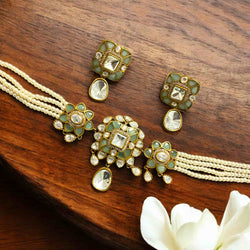Malika gold plated moissanite pearl choker necklace set from Romikas Jewelry featuring intricate floral design with brilliant moissanite stones, teal doublet gemstone accents, lustrous pearl strands, and teardrop dangles. Complete bridal wedding jewelry set includes matching drop earrings with same gold plated finish, moissanite stones, and teal doublets. Indian Kundan style traditional jewelry perfect for weddings, engagements, special occasions. 