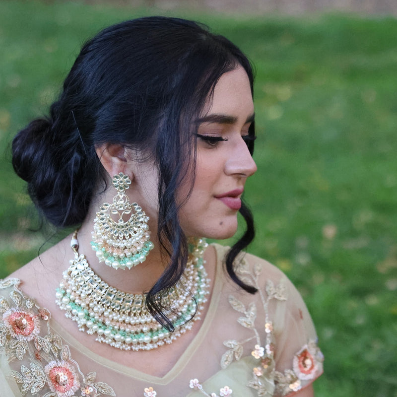 Model wearing a kundan necklace set featuring Indian Jewelry with kundan, mint and pink beads and pearls.