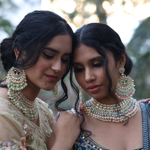 Two models showcasing high qulaity kundan sets with multicolor beads and pearls.