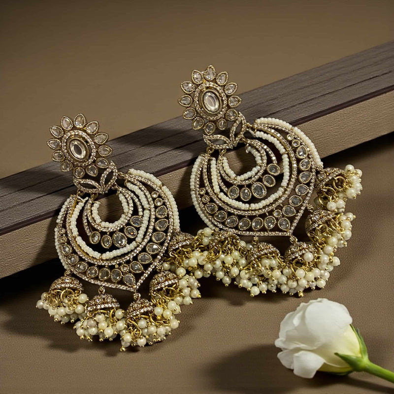 Shop beautiful Kundan and pearl gold plated chandbali earrings with intricate floral detailing. Ideal Indian jewelry for brides and festive celebrations.