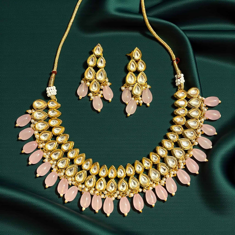Pink beaded Kundan necklace in gold plating, shown in a flatlay style. Traditional Indian bridal jewelry featuring intricate Kundan stones and soft bead drops. Ideal accessory for weddings, receptions, festivals, and ethnic fashion styling.