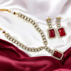 Elegant Kundan and Cubic Zirconia necklace set in black finish featuring a stunning ruby centerpiece. This statement jewelry set includes matching earrings, perfect for weddings, festive occasions, and South Asian bridal wear. Traditional yet modern ethnic jewelry.