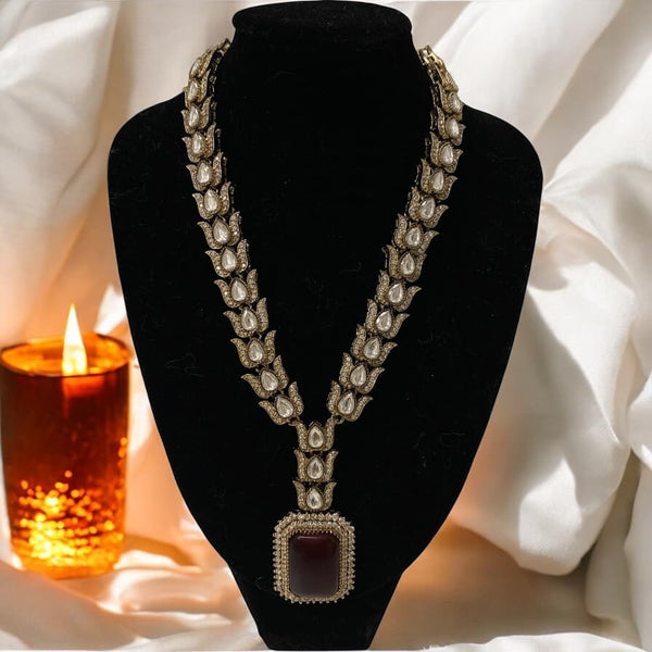 Kundan and CZ necklace set in black finish with a bold ruby stone. Paired with matching earrings, this statement piece is perfect for bridal wear, weddings, and festive occasions. A blend of traditional craftsmanship and modern elegance for South Asian jewelry lovers.