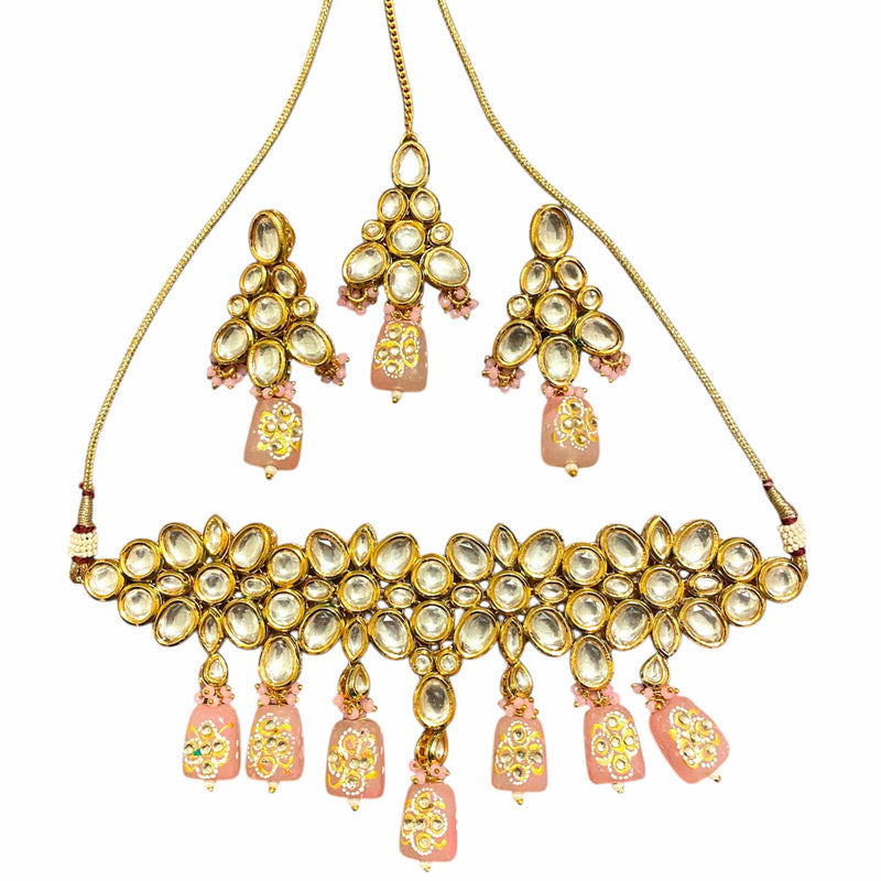 Beautiful Pink Kundan Choker Necklace Set with Meenakari back design, handcrafted in gold plating with sparkling Kundan stones and pink Monalisa beads. Comes with matching earrings and maang tikka for a complete Indian bridal jewelry set. Perfect for weddings, receptions, and festive occasions, this elegant traditional choker necklace enhances any saree or lehenga with its regal charm and intricate craftsmanship. Ideal for brides and ethnic jewelry lovers.