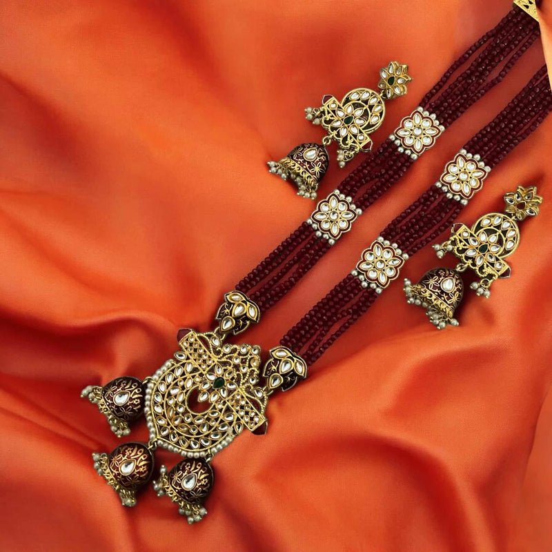 Pritha Maroon Kundan long necklace set with pearls, gold-plated finish, and intricate meenakari work. Includes matching earrings. Perfect for Indian weddings, bridal jewelry, festive occasions, and traditional celebrations. This handcrafted South Asian jewelry set features rich maroon beads and Kundan craftsmanship, adding a royal touch to any ethnic outfit. Ideal for brides, bridesmaids, and wedding guests looking for elegant and timeless jewelry pieces.