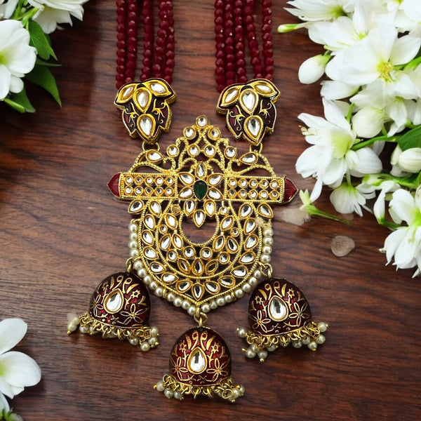 Maroon Kundan long necklace set from the Pritha collection, featuring gold-plated details, pearl accents, and meenakari craftsmanship. This traditional Indian jewelry set includes matching earrings and is perfect for bridal wear, weddings, festivals, and special occasions. The rich maroon beads and intricate Kundan work make it a standout South Asian accessory for ethnic outfits. Elegant and timeless design for brides and cultural celebrations.