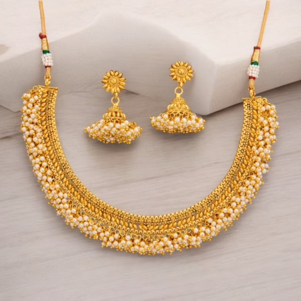 Antique gold necklace set with intricate design, adorned with pearls and paired with matching jhumka earrings. Traditional South Indian temple jewelry, perfect for weddings and festive occasions.