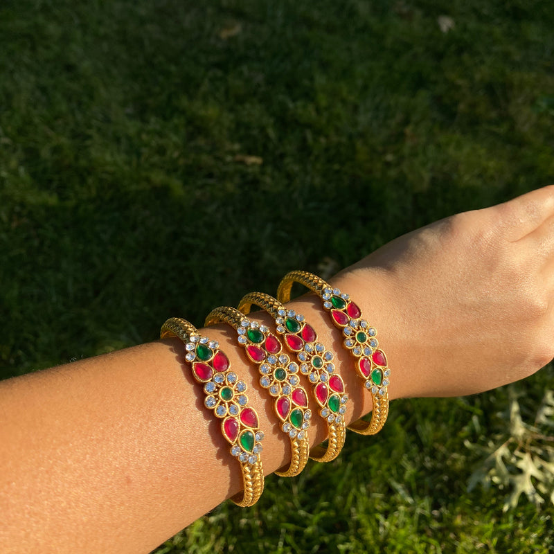 Model Wearing Gold Bangles with Red and Green Stone and Kundan from Indian Jewelry.