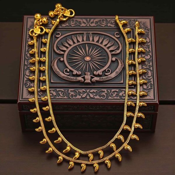 Gold plated Indian payal anklet with delicate dangling charms displayed on plain background. Traditional ethnic foot jewelry for women, perfect for bridal wear, festive outfits, and gifting. Handcrafted design with bright gold shine.