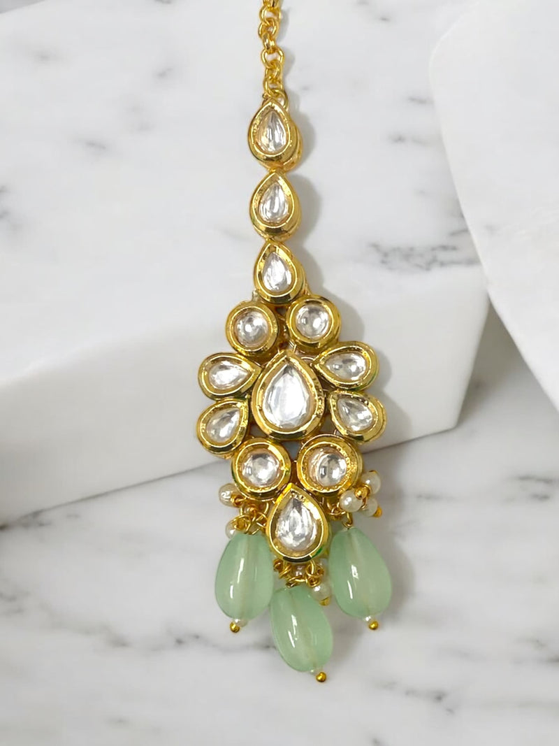 This exquisite mint Kundan maang tikka features intricate craftsmanship, making it essential for bridal jewelry and traditional Indian attire. Perfect for weddings, haldi ceremonies, and festive occasions, this stunning accessory elevates your look. The refreshing mint hue beautifully complements various outfits, adding elegance and charm. A must-have for any online Indian jewelry collection, this luxurious maang tikka combines timeless beauty with contemporary style, ensuring you shine on your special day 