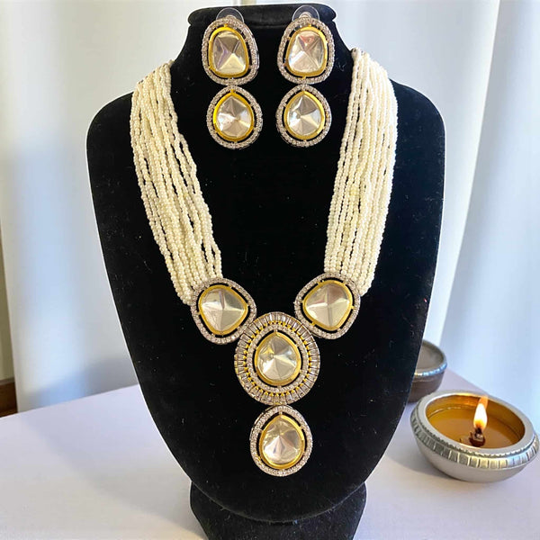 Jewelry set with necklace and earrings on a black stand. Luxury pearl Kundan necklace set with layered pearls and a radiant silver foil Polki pendant bordered by CZ stones. The matching earrings complete the look, making it ideal for bridal wear or festive celebrations. Handcrafted with premium materials, this necklace set showcases timeless Indian craftsmanship, offering a perfect blend of elegance, tradition, and refined beauty.