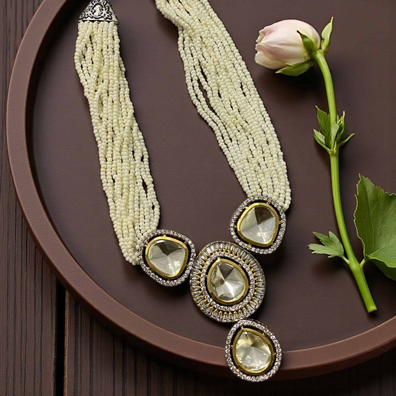 Elegant pearl Kundan necklace set featuring a stunning multi-layer pearl mala and a large silver foil Kundan pendant surrounded by sparkling CZ stones. The set includes matching statement earrings, handcrafted to perfection with a gold and silver dual-tone finish. Perfect for brides, weddings, or festive occasions, this traditional Indian jewelry piece exudes royal charm and timeless elegance.