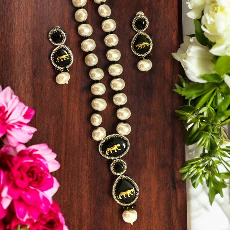 Sabyasachi-inspired long necklace set featuring baroque pearls with a black stone pendant and tiger motif. Includes intricately designed matching earrings with black stone and pearls. Perfect for bridal wear, weddings, or festive occasions.