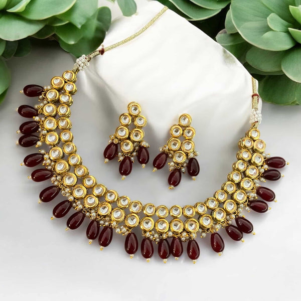 High quality Kundan necklace set with intricate back meenakari and rich maroon beads. This handcrafted Indian jewelry set includes a matching pair of earrings. Ideal for Indian bridal wear, wedding jewelry, and festive occasions. Perfect with sarees, lehengas, and anarkalis. Features premium Kundan work and traditional craftsmanship. A statement ethnic necklace set for South Asian brides and festive celebrations. Add elegance and timeless charm to your ethnic jewelry collection.