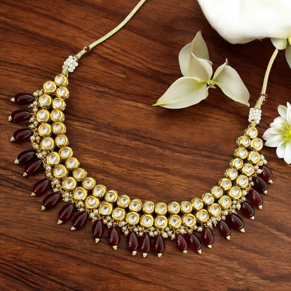Elegant Kundan necklace set with detailed back meenakari and deep maroon beads, handcrafted for Indian weddings, bridal wear, and festivals. Includes matching earrings for a complete ethnic look. Premium quality traditional Indian jewelry that complements bridal sarees, lehengas, and festive outfits. A must-have statement piece for South Asian bridal collections and festive occasions.