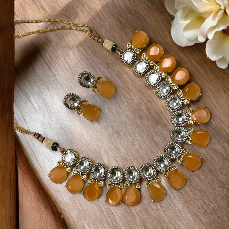 Elegant Peach Shibani Kundan Necklace Set with intricate Kundan work, shimmering American Diamonds, and soft peach Monalisa beads in a gold-plated finish. A perfect bridal necklace for weddings, festive events.