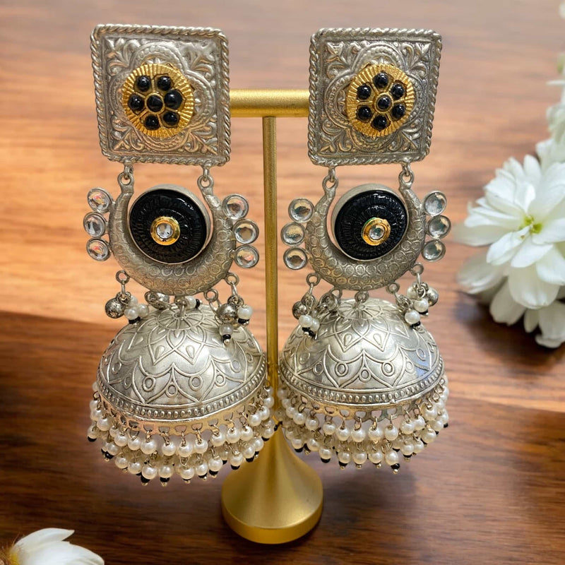 Sunehri 92.5 silver-coated black jhumka earrings with white pearls – elegant traditional Indian jewelry featuring a bold black dome, intricate handcrafted silver detailing, and classic pearl hangings. A perfect choice for festive celebrations, weddings, and ethnic wear. These statement earrings blend modern sophistication with timeless charm, ideal for pairing with sarees, lehengas, and Indo-western outfits. A must-have accessory for South Asian fashion lovers.


