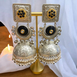 Sunehri 92.5 silver-coated black jhumka with pearls – traditional Indian earrings featuring intricate silver finish, bold black base, and delicate pearl drops. Perfect ethnic jewelry for weddings, festive occasions, and cultural events. Handcrafted statement jhumka ideal for pairing with sarees, lehengas, and Indo-western outfits. Elegant South Asian jewelry for women seeking timeless charm and modern elegance.
