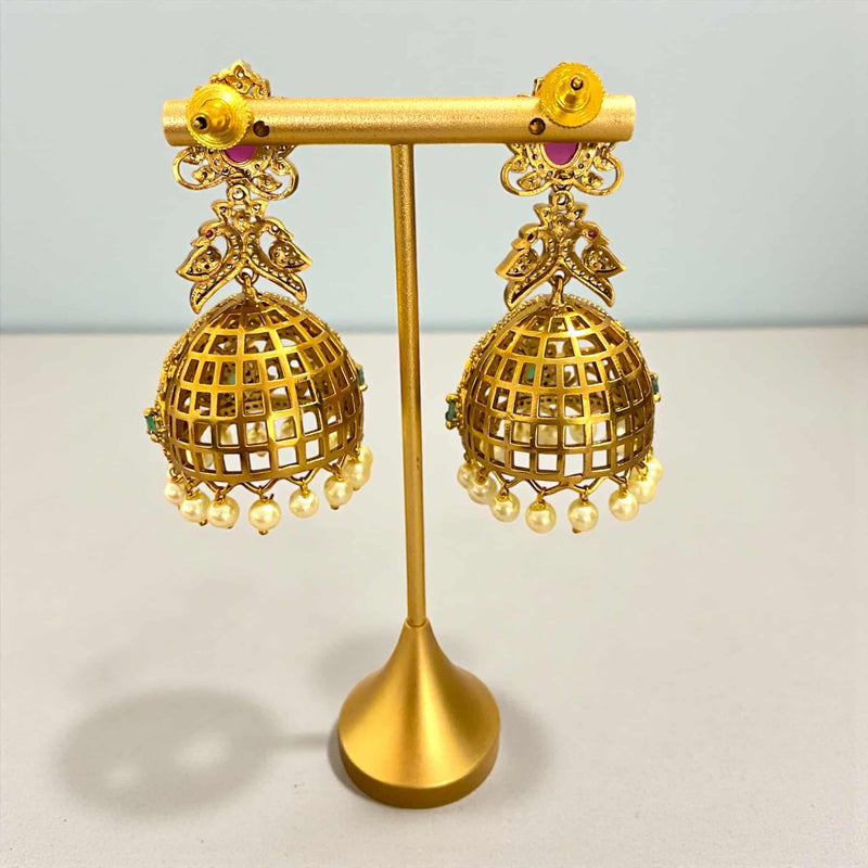 Gold CZ jhumka earrings with ruby stone studs, emerald teardrop accents, and sparkling cubic zirconia detailing. Designed in a high-quality gold-plated finish with intricate filigree work and elegant pearl hangings. Traditional Indian jewelry perfect for weddings, festivals, parties, and South Asian outfits.