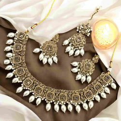 High-end Polki necklace set with pearls, featuring a statement choker-style necklace, matching earrings, and a coordinating maang tikka. Traditional Indian bridal jewelry handcrafted with intricate Kundan Polki work and elegant pearl detailing. Perfect for South Asian weddings, bridal wear, and festive occasions. Luxurious gold-plated finish ideal for Desi brides seeking regal, ethnic jewelry sets.