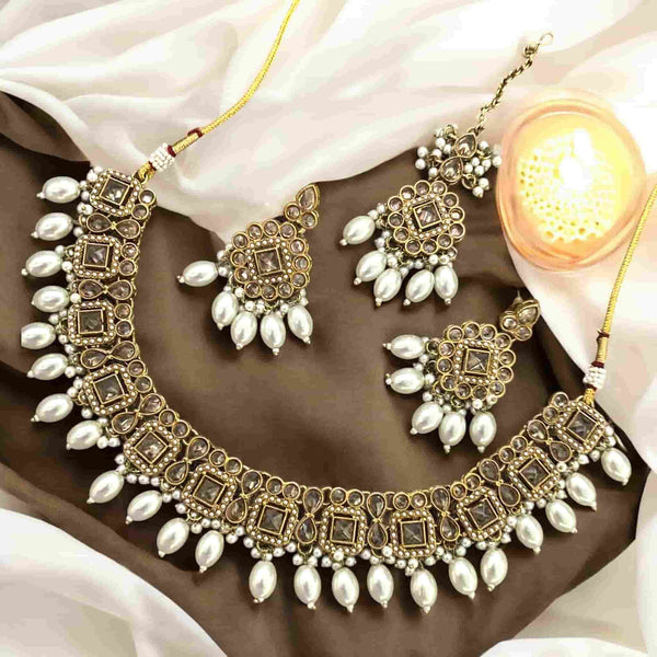 High-end Polki necklace set with pearls, featuring a statement choker-style necklace, matching earrings, and a coordinating maang tikka. Traditional Indian bridal jewelry handcrafted with intricate Kundan Polki work and elegant pearl detailing. Perfect for South Asian weddings, bridal wear, and festive occasions. Luxurious gold-plated finish ideal for Desi brides seeking regal, ethnic jewelry sets.