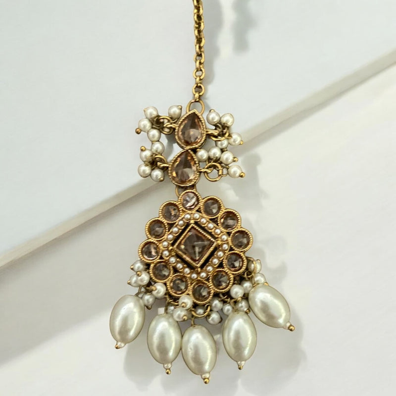 High-end Polki maang tikka with pearls, featuring intricate Kundan Polki work in a traditional gold-plated finish. Elegant Indian bridal forehead accessory perfect for weddings, festive occasions, and South Asian ceremonies. Handcrafted with luxurious pearl detailing for a regal and timeless look. Ideal ethnic jewelry piece for Desi brides seeking a statement maang tikka to complete their wedding ensemble.