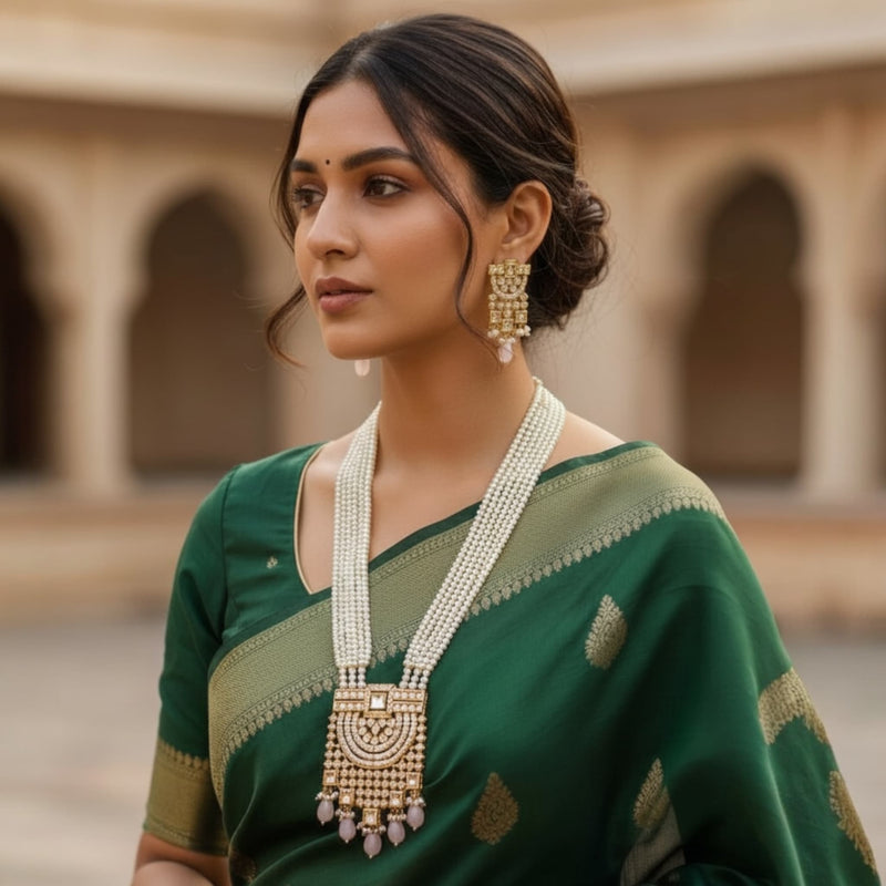 Woman wearing a long pearl necklace featuring layered pearls, intricate Kundan work, and soft pink Monalisa stones. Elegant Indian bridal necklace perfect for weddings, receptions, and festive wear. The statement Kundan pendant adds a luxurious traditional touch to lehengas and sarees.