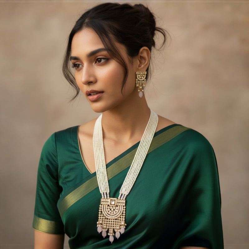 Model showcasing a long pearl Kundan necklace with multi-layer pearls and pink Monalisa stones. Perfect Indian bridal jewelry for weddings and special occasions. The detailed Kundan pendant adds sophistication and pairs beautifully with sarees, lehengas, and festive outfits.