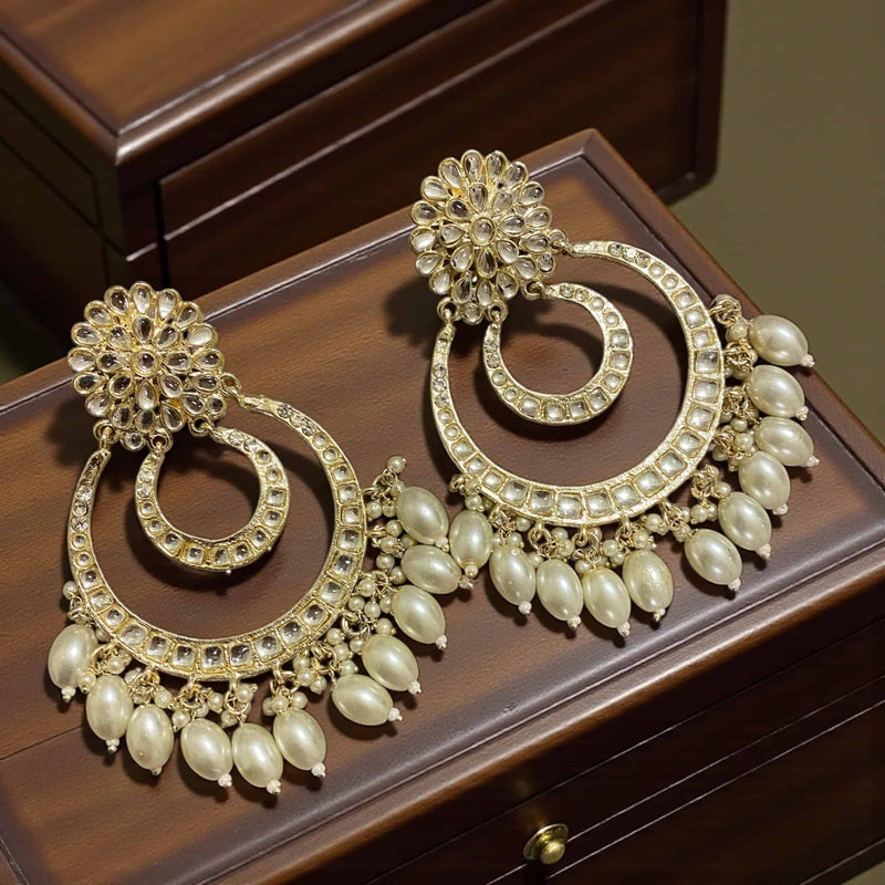 Handcrafted gold plated Kundan chandbali earrings adorned with delicate pearl drops and intricate stone detailing. These elegant Indian earrings feature traditional craftsmanship and a timeless circular design, perfect for weddings, festive occasions, and cultural celebrations. Lightweight and luxurious, they beautifully complement sarees, lehengas, and anarkalis for an authentic ethnic look.
