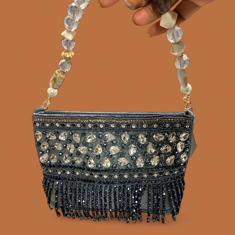 Grey beaded clutch with shimmering stone work and crystal handle available at Romikas Jewelry Shop. Handcrafted Indian evening purse perfect for weddings, receptions, and festive events. Elegant design combines traditional craftsmanship with modern style.