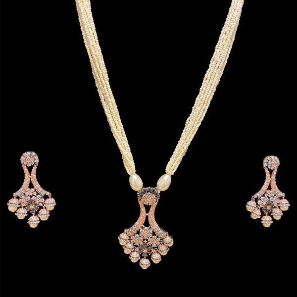 Long Necklace made with rice pearl strands with a cubic zirconia pendant with micor/pave settings in victorian finish.