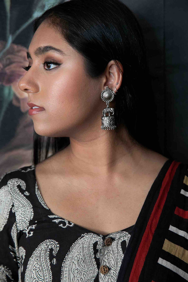 Model wearing Gaja jhumka earrings: oxidized silver - Romikas